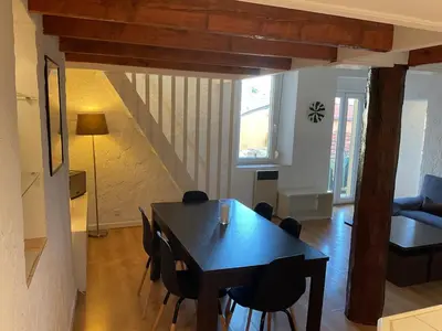 a dining table and chairs in a living room at Duplex Apartment Old Town & Beach in Villefranche-sur-Mer