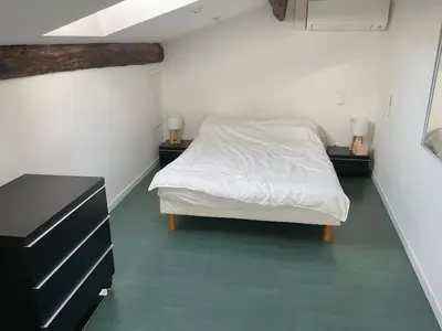 a bedroom with a white bed and two night stands at Duplex Apartment Old Town & Beach in Villefranche-sur-Mer