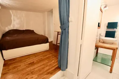 a small bedroom with a bed and a sink at Charmant appartement au sein de la vieille ville in Villefranche-sur-Mer