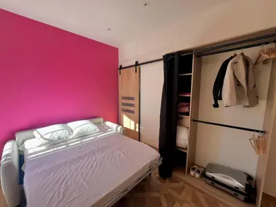 a bedroom with a pink wall and a bed at Studio Ciste avec terrasse à Cagnes-sur-Mer in Cagnes-sur-Mer