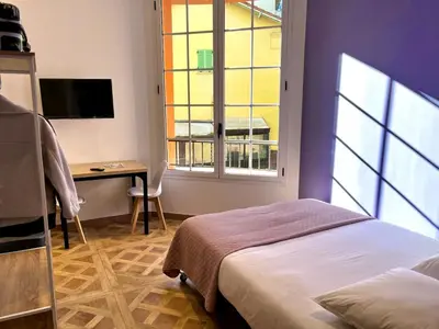 a bedroom with a bed and a desk and a window at Studio Lavande cosy et central à Cagnes-sur-Mer in Cagnes-sur-Mer