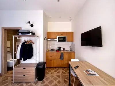 a living room with a table and a kitchen at Studio Lavande cosy et central à Cagnes-sur-Mer in Cagnes-sur-Mer