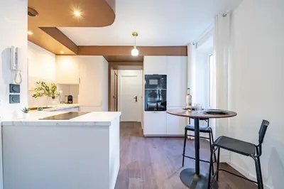 a kitchen with a table and a kitchen with white cabinets at Appartement cosy au coeur de Cagnes sur Mer in Cagnes-sur-Mer