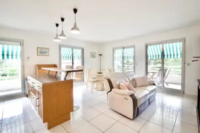 a living room with a couch and a table at Terrasse, piscine & parking sur la Côte d'Azur in Saint-Laurent-du-Var