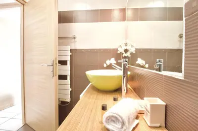 a bathroom with a large green bowl sink in it at Terrasse, piscine & parking sur la Côte d'Azur in Saint-Laurent-du-Var