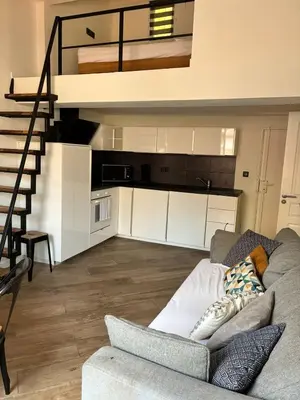 a living room with a couch and a staircase at Magnifique 2P Vieux Nice AC-WIFI in Nice