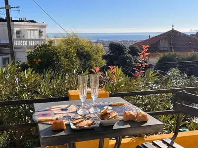 a table with bread and wine glasses on a balcony at Villa Arty Nice - Vue Mer Panoramique, Piscine & Design in Nice