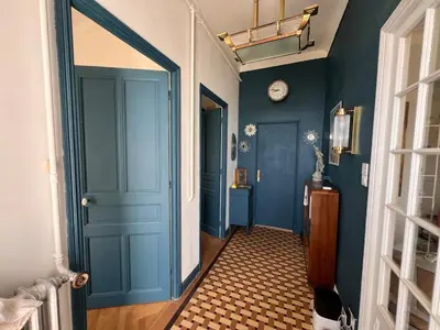 a hallway with a blue door and a clock at Villa Arty Nice - Vue Mer Panoramique, Piscine & Design in Nice