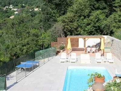 a swimming pool with white chairs and a gazebo at Holiday Home Rocabel mit Blick auf das Wasser by Interhome in Gattières