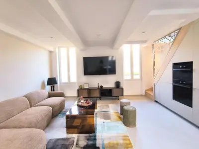 a living room with a couch and a tv at Elegant Renovated Apartment Nice Port AC Sleeps 4 in Nice