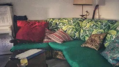 a couch with pillows on it in a living room at Shared Appartment with Kitten in Nice