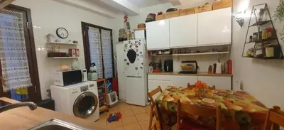 a kitchen with a table and a refrigerator at Shared Appartment with Kitten in Nice