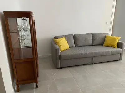 a living room with a couch and a glass cabinet at Cosy Nice Promenade des Anglais Beach Apartment 2 rooms in Nice