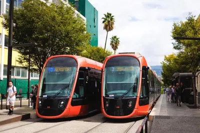 two orange buses parked next to each other on a street at Cosy Nice Promenade des Anglais Beach Apartment 2 rooms in Nice