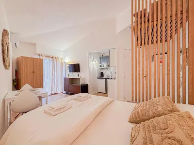 a white bedroom with a large bed in a room at Proche mer - 2 pers, AC in Nice