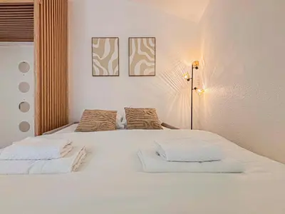 a bedroom with a white bed with two pillows at Proche mer - 2 pers, AC in Nice