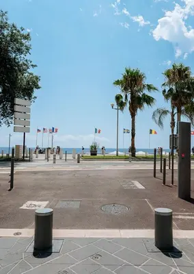 a empty parking lot with palm trees and the ocean at Joli studio rénové vieux Nice in Nice