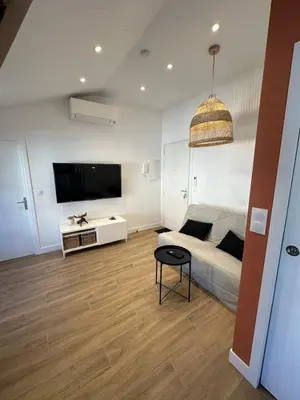 a living room with a bed and a tv at Appartement Neuf Nice Carré Or à 2 pas de la mer tout équipé in Nice