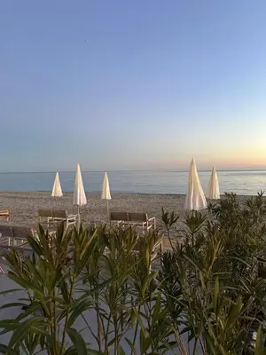 a group of white umbrellas on a beach at Appartement Neuf Nice Carré Or à 2 pas de la mer tout équipé in Nice