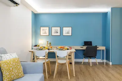 a dining room with a table and a blue wall at MY CASA - SUISSE - Cosy Apartment Down Town with terrasse in Nice