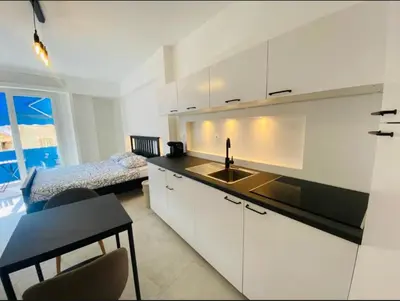 a kitchen with a sink and a bedroom with a bed at Magnifique studio avenue des diables bleus in La Celle-sous-Gouzon