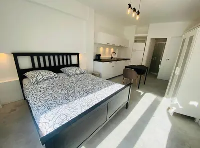 a bedroom with a large bed and a kitchen at Magnifique studio avenue des diables bleus in La Celle-sous-Gouzon