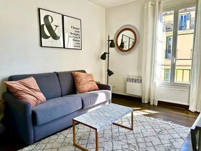a living room with a blue couch and a table at Studio cosy proche des plages & promenade in Nice