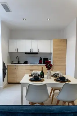 a kitchen with a white table and white cabinets at Bright apartment in Nice in Nice