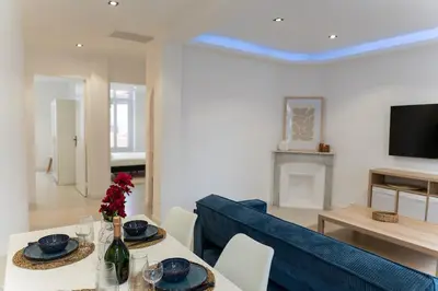 a living room with a table and a blue couch at Bright apartment in Nice in Nice