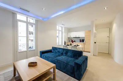 a living room with a blue couch and a table at Bright apartment in Nice in Nice