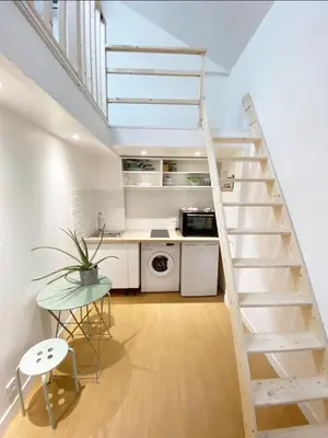 a white kitchen with a staircase in a room at Duplex studio 50 mètres de la plage in Nice
