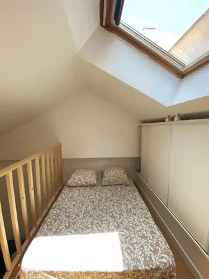 a small bedroom with a bed in a attic at Duplex studio 50 mètres de la plage in Nice