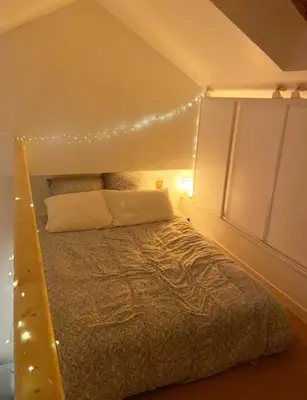 a bedroom with a bed with lights on it at Duplex studio 50 mètres de la plage in Nice