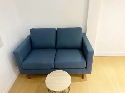 a blue couch in a living room with a table at Duplex studio 50 mètres de la plage in Nice