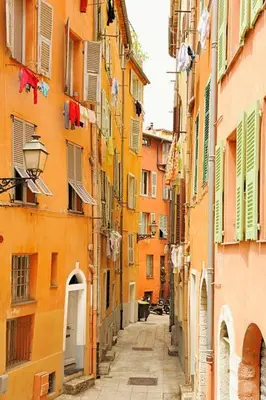 an alley with colorful buildings and a street with laundry at Le Notre Dame - 2 pièces au cœur de Nice in Nice