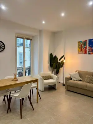 a living room with a table and a couch at Le Notre Dame - 2 pièces au cœur de Nice in Nice