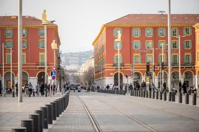 a city street with buildings and a statue of a woman at Le Notre Dame - 2 pièces au cœur de Nice in Nice