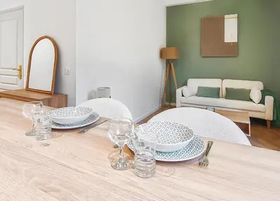 a dining table with plates and wine glasses on it at T2design, élégant & calme à Nice in Nice