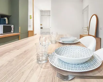 a table with plates and glasses on a wooden table at T2design, élégant & calme à Nice in Nice