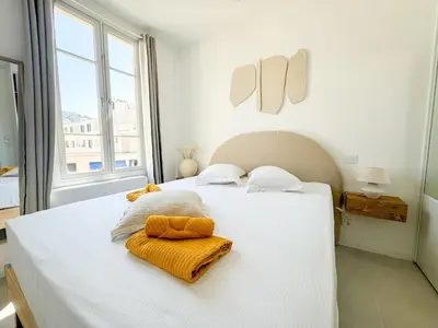 a bedroom with a white bed with towels on it at Confortable & Élégant climatisé au Port de Nice in Nice