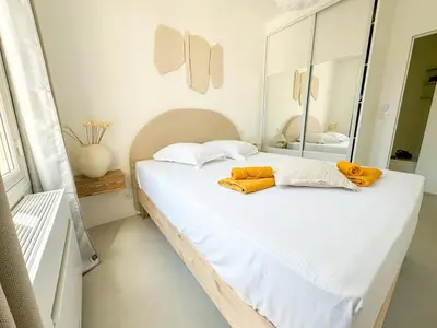 a bedroom with a large white bed with a mirror at Confortable & Élégant climatisé au Port de Nice in Nice
