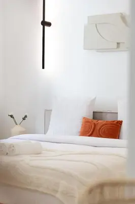 a bed with white sheets and orange pillows at Coup de cœur 3 couchages Quartier du Port in Nice