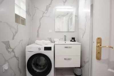 a bathroom with a washing machine and a sink at Confort, modernité & calme au Port de Nice in Nice
