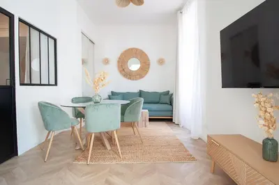 a living room with a table and a blue couch at Confort, modernité & calme au Port de Nice in Nice