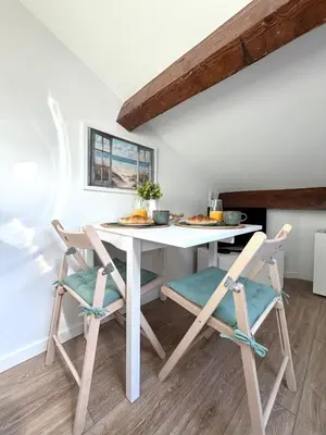 a bedroom with a mirror and a vase of flowers at LE PETIT NID sous le toit in Nice
