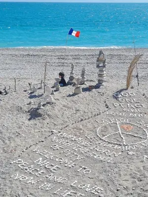 a bench sitting on the beach near a fence at LE PETIT NID sous le toit in Nice