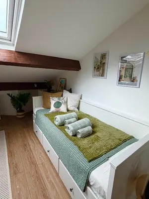 a bedroom with a bed and a table at LE PETIT NID sous le toit in Nice