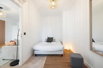 a bedroom with a bed and a mirror and a chair at Grand T4 chic près du Port Balcon & Clim in Nice