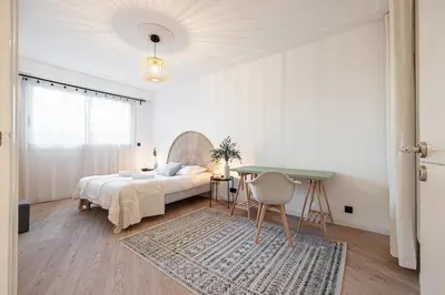 a white bedroom with a bed and a table at Grand T4 chic près du Port Balcon & Clim in Nice
