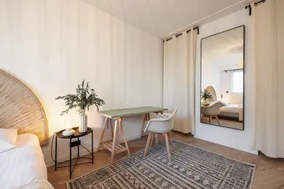a bedroom with a bed and a table and a mirror at Grand T4 chic près du Port Balcon & Clim in Nice
